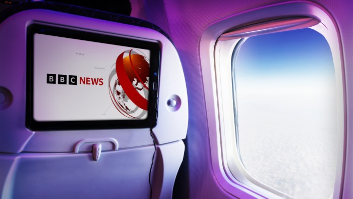Airline flight cabin showing BBC World News on screen